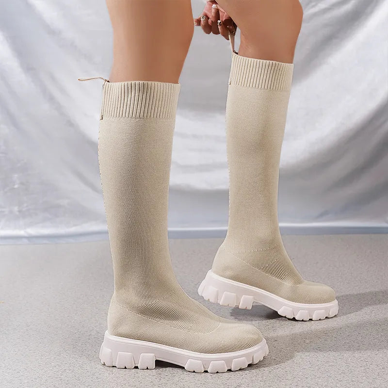 Angled shot of trendy women's stretchy knit chunky boots, key for cold weather and fashion.
