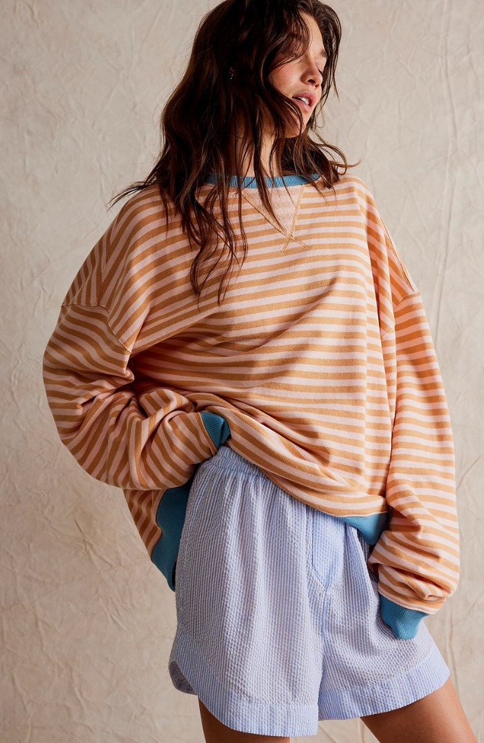 Stylish women's striped crewneck sweater paired with jeans, showcasing a casual look.