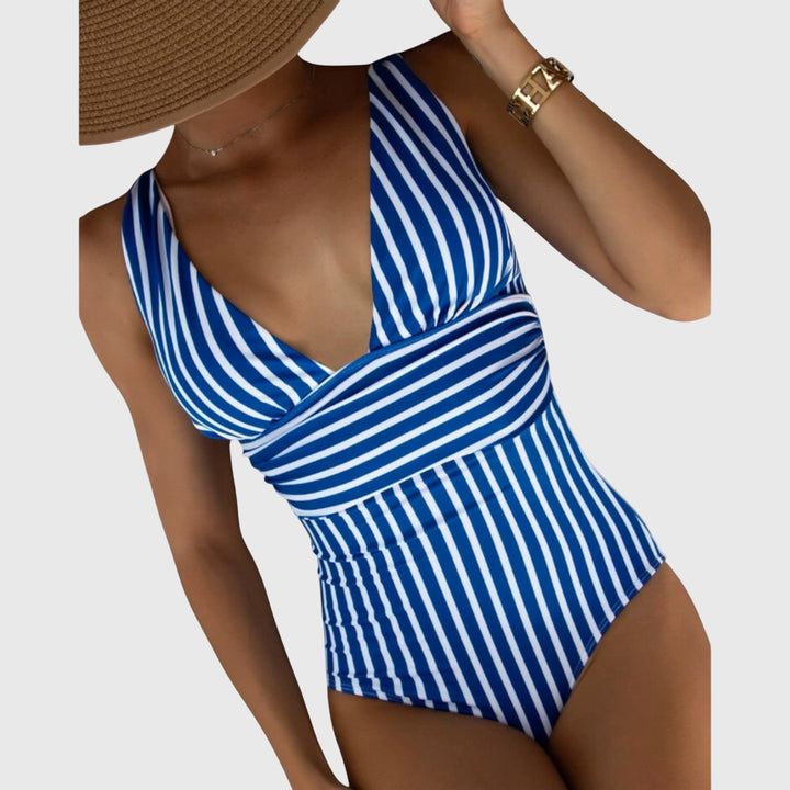 Model wearing a stylish striped V-neck one-piece swimsuit, ready for summer beachwear
