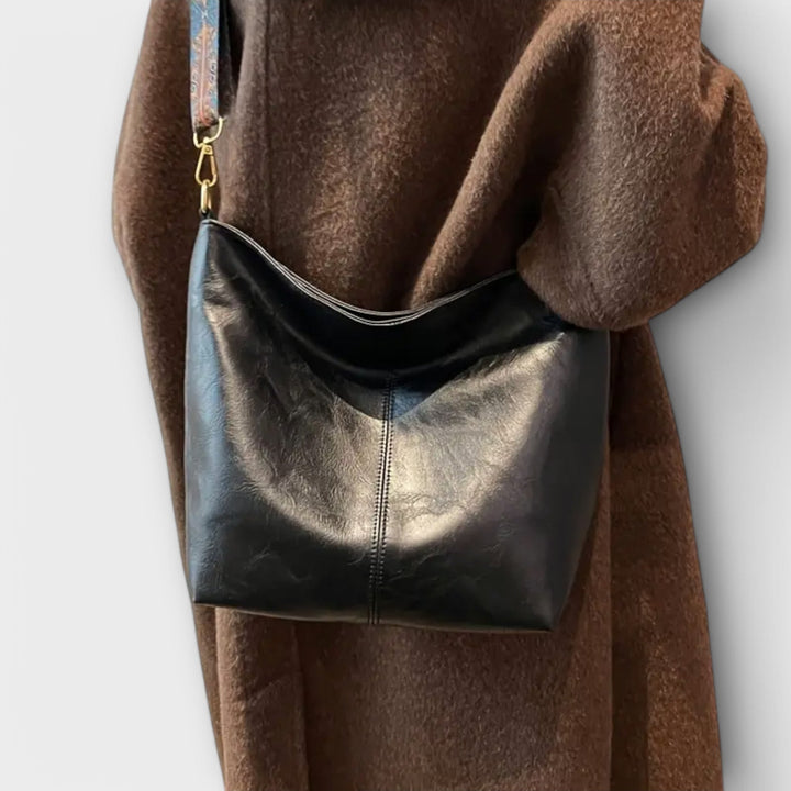 Women's shoulder bag in classic black, elegantly styled with unique braided detailing