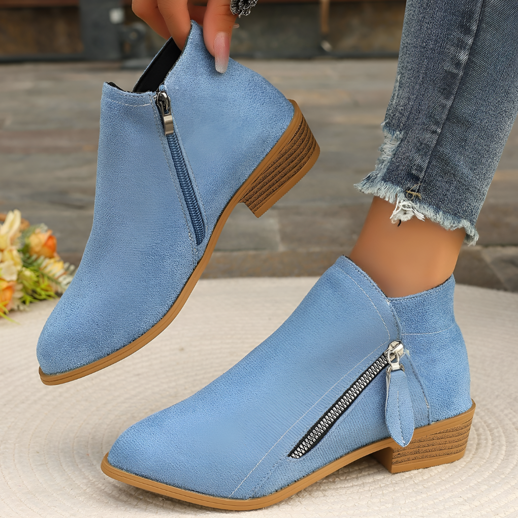 Close-up of a women's brown suede ankle boot, highlighting texture and side zipper detail