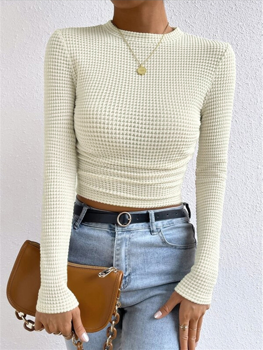 Women's stylish long sleeve crop top in textured knit, perfect for spring fashion.