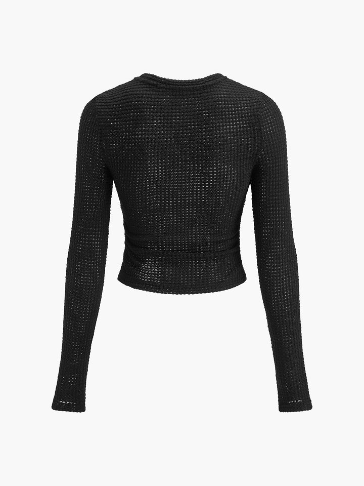 Women's fitted long sleeve crop top, showcasing its soft textured knit material.