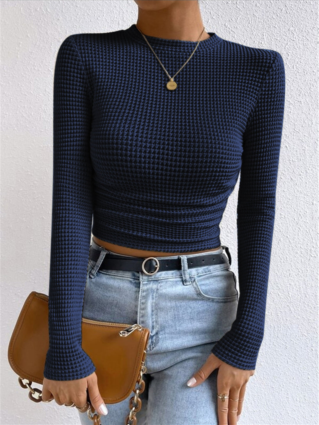 Long sleeve crop top in a soft pink, adding a pop of color to women's spring fashion.