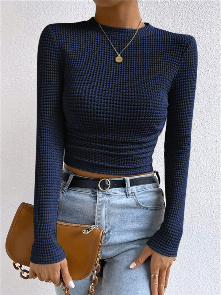 Long sleeve crop top in a soft pink, adding a pop of color to women's spring fashion.