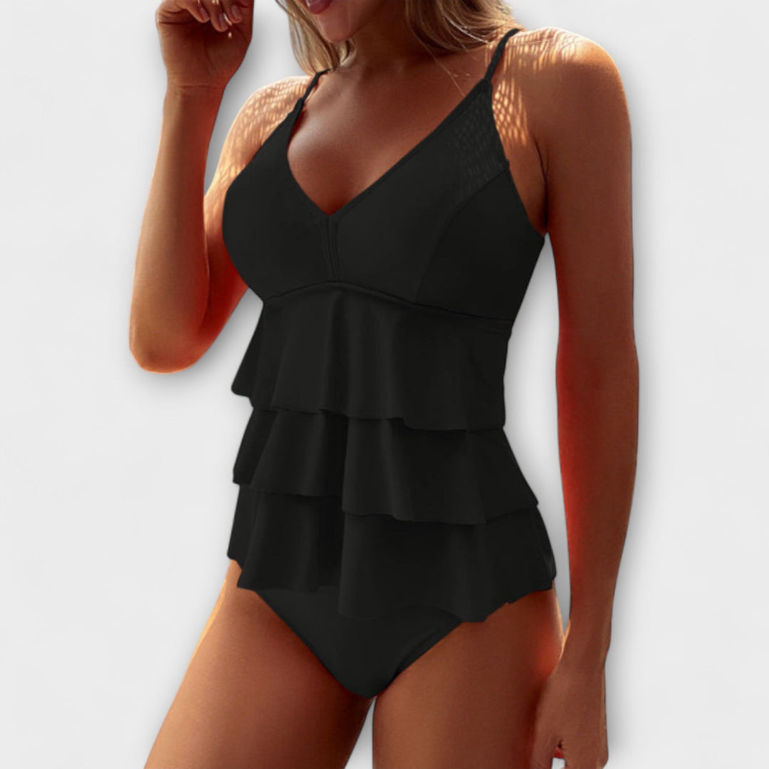 Women's black ruffle tiered V-neck one-piece swimsuit, versatile and chic beachwear for any vacation.