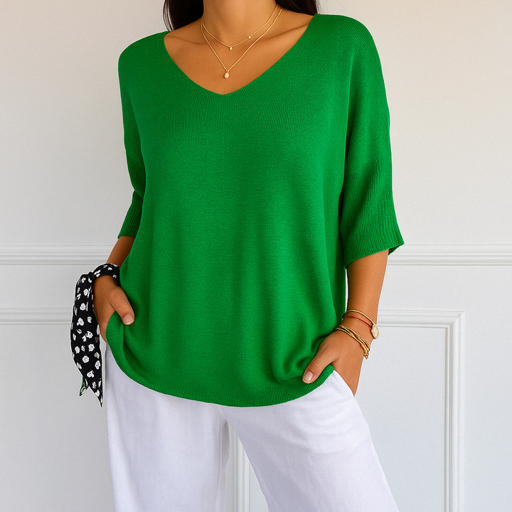 Model smiling while wearing a pink V-neck short sleeve lightweight sweater, comfortable and trendy.
