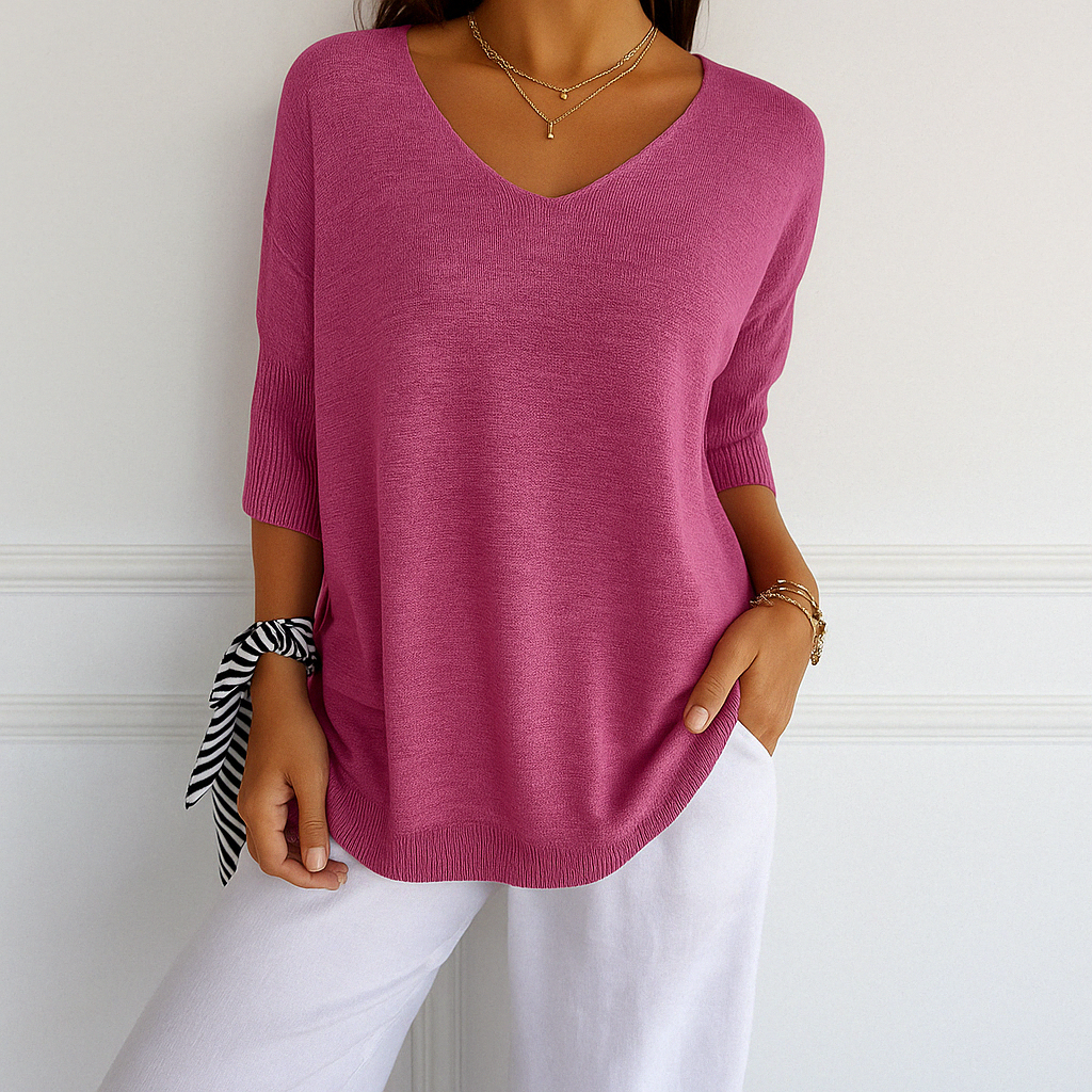 Woman comfortably wearing a white V-neck short sleeve lightweight sweater, showcasing relaxed fit.