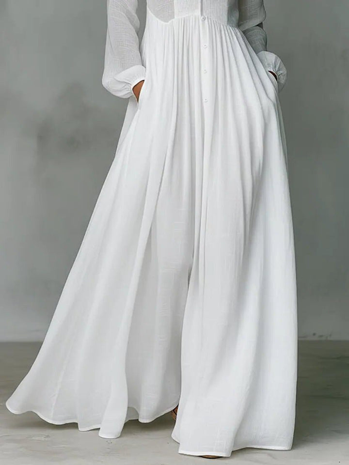 Full-length women's maxi shirt dress with stand collar, button front, and practical pockets, styled elegantly.