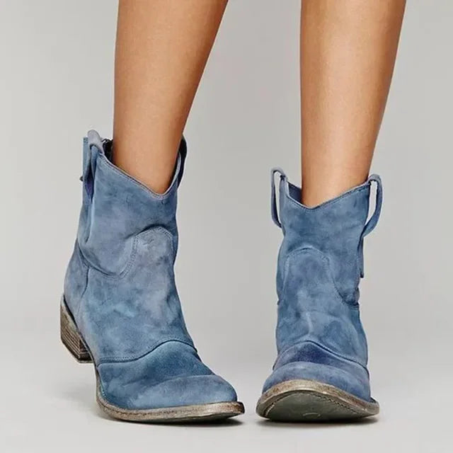Close-up of women's vintage western style suede ankle boots with detailed stitching