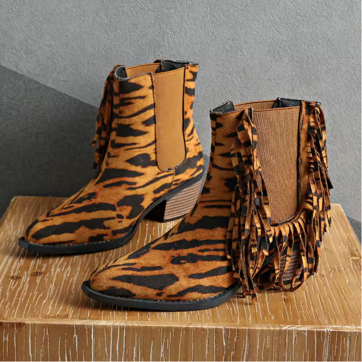 Stylish women's Western ankle boots made of suede with decorative fringe and comfortable block heel.