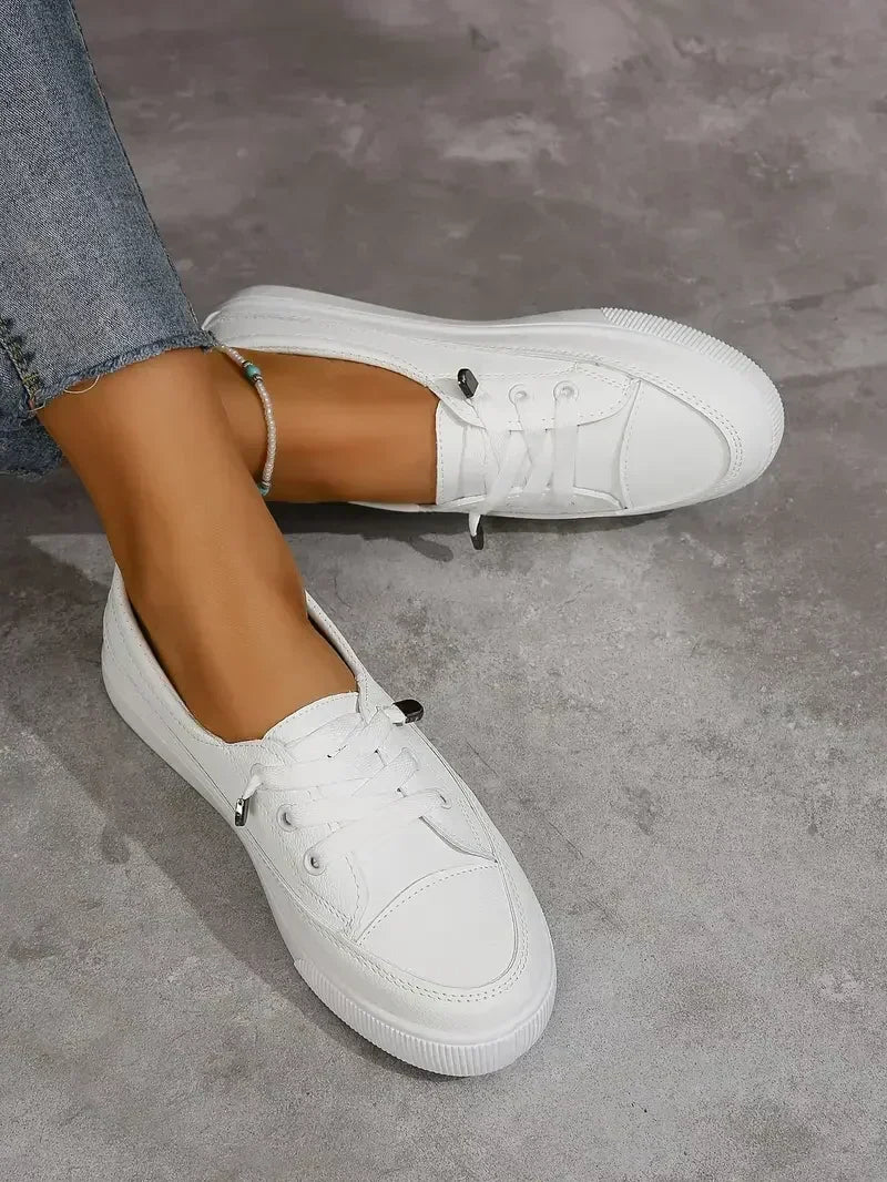 Everyday white women's casual flats, featuring a comfortable round toe and secure lace-up design.