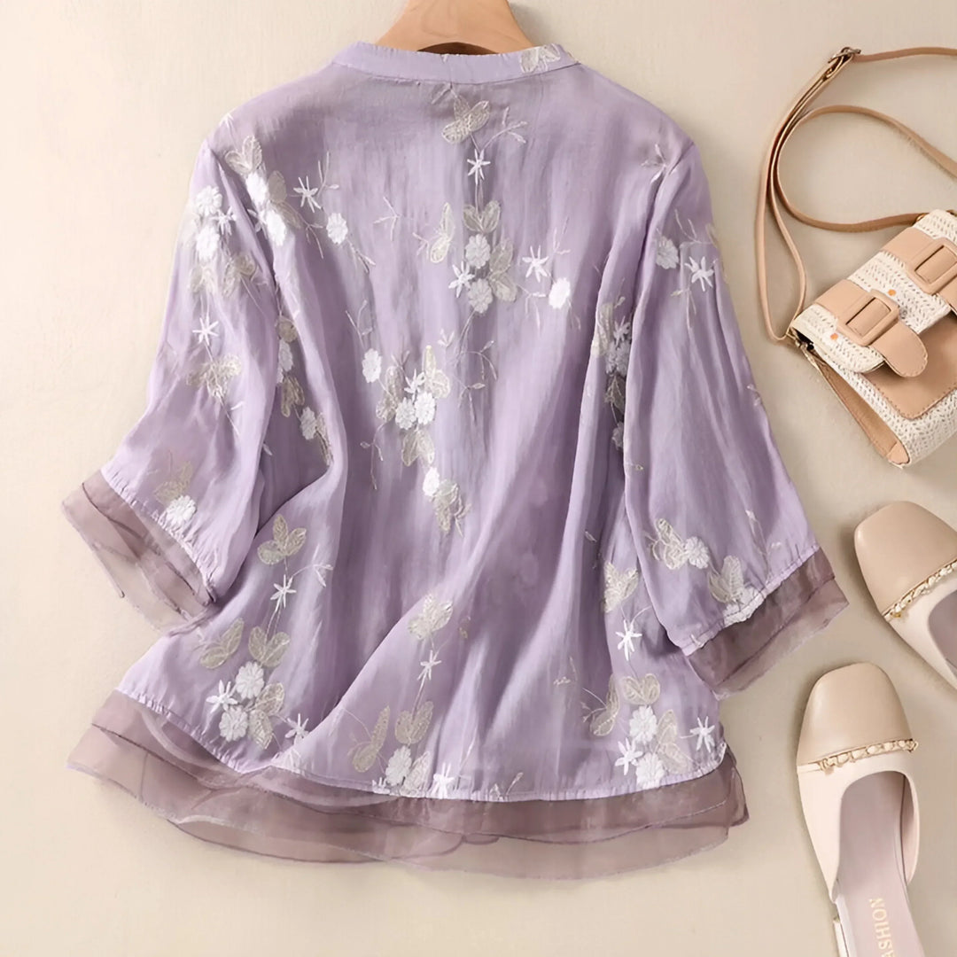 Close-up of intricate floral embroidery on a white cotton casual women's blouse