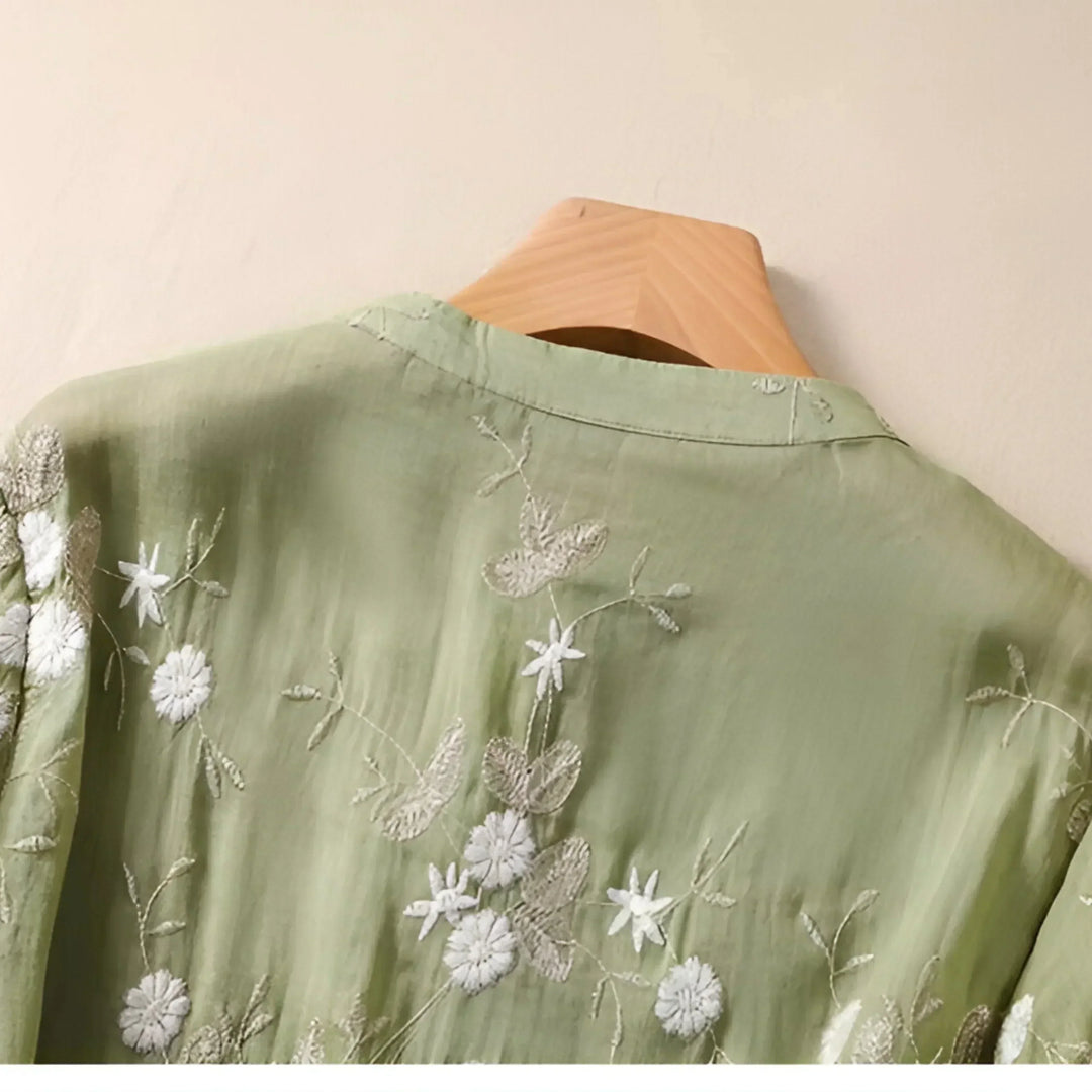 Back view of a plain white cotton women's top, emphasizing embroidered floral front