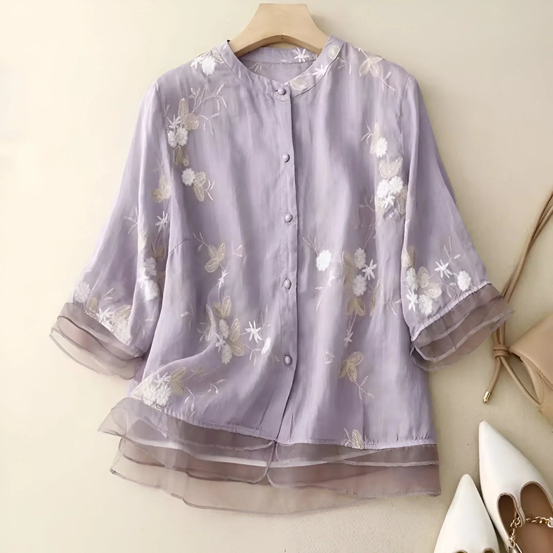 Woman wearing a white cotton floral embroidered top, styled casually outdoors