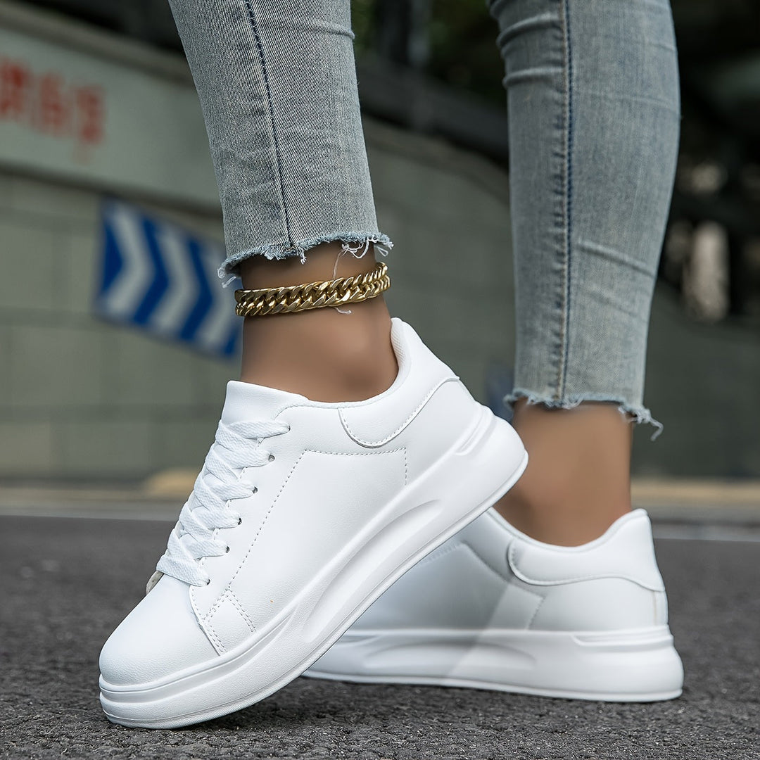 New women's white leather sneakers, essential spring fashion footwear for a minimalist look.