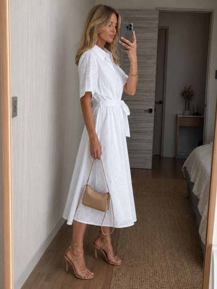 Comfortable white short sleeve midi dress for women, featuring a button front, waist tie & elegant collar. Versatile summer wear.