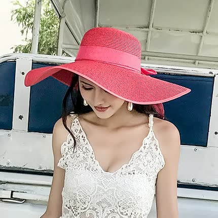 Fashionable women's straw sun hat with wide brim & chic bow detail, ideal for summer style & accessories.