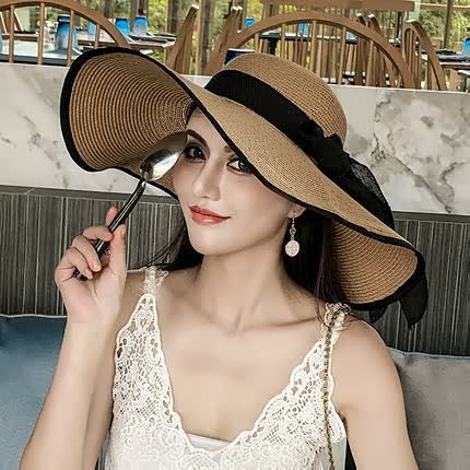 Hand-woven straw sun hat for women, featuring a wide brim & delicate bow, a classic summer accessory.