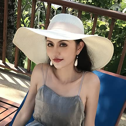 Women's wide brim straw sun hat with bow; a stylish, protective beach & summer vacation accessory.