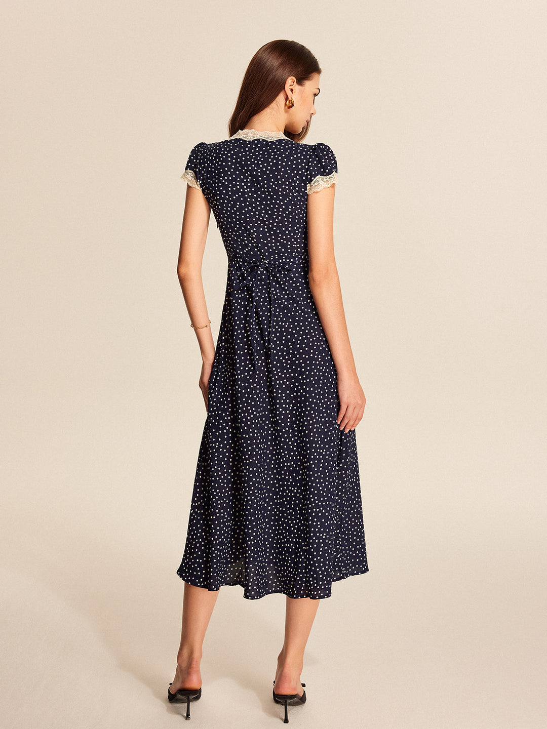 Flowy polka dot maxi dress for women, featuring a V-neck and delicate lace trim. Perfect summer look.