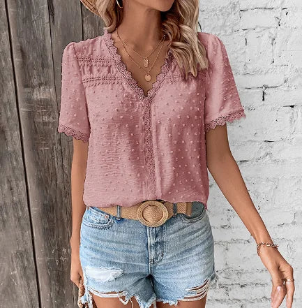 Woman wearing a stylish Swiss dot V-neck lace blouse with short sleeves, a perfect blend of elegant and casual.