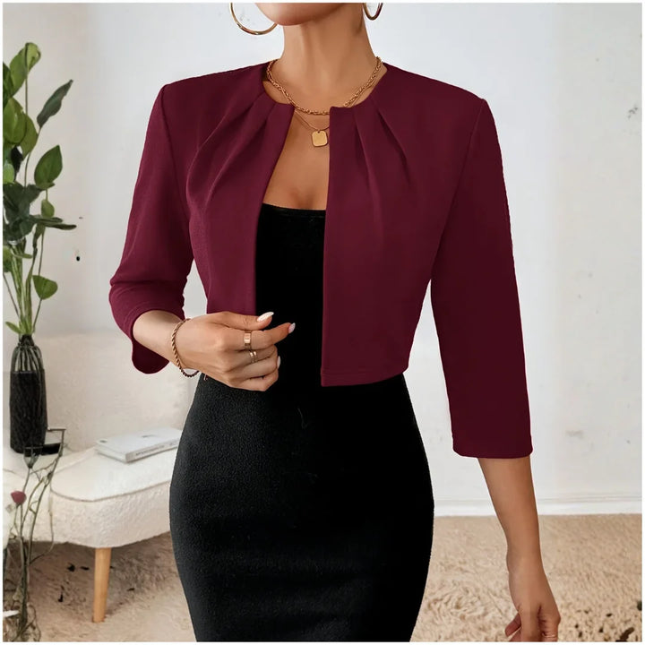 Studio image of a women's cropped open front 3/4 sleeve pleated blazer, clean and professional.
